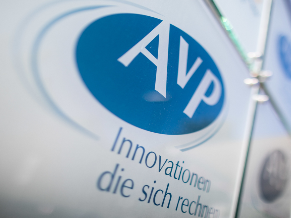 Das Firmenschild von AvP hängt vor dem Eingang des Gebäudes. | Foto: picture alliance/Marcel Kusch/dpa