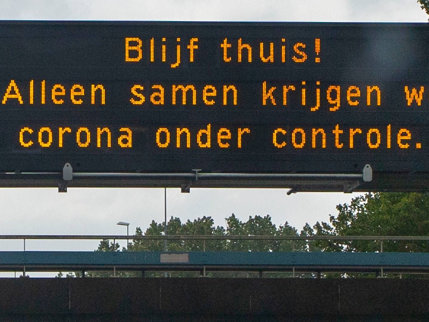 "Bliv hjemme - kun sammen får vi corona under kontrol," står der på dette hollandske skilt, men nedlukningen har ført til et massivt fald i arbejdsindkomst verden over. | Foto: Peter Dejong/AP/Ritzau Scanpix