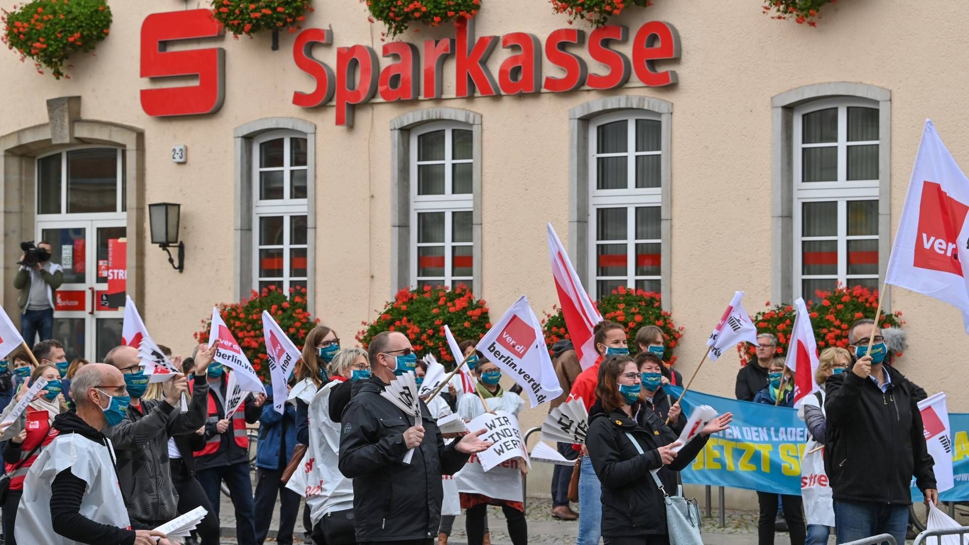 Teilnehmer der Zentralen Kundgebung im Warnstreik der Sparkassen stehen vor dem Gebäude der Sparkasse Märkisch-Oderland | Foto: picture alliance/Patrick Pleul/dpa-Zentralbild/ZB