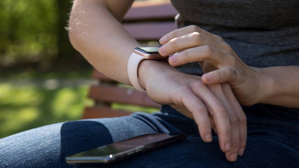 Eine Frau synchronisiert in einem Park in Hamburg ihre Smart Watch mit ihrem Smartphone | Foto: picture alliance/dpa Themendienst