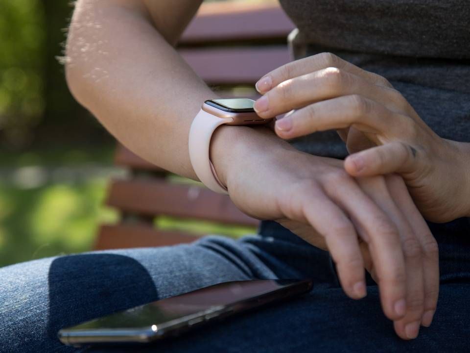 Eine Frau synchronisiert in einem Park in Hamburg ihre Smart Watch mit ihrem Smartphone | Foto: picture alliance/dpa Themendienst