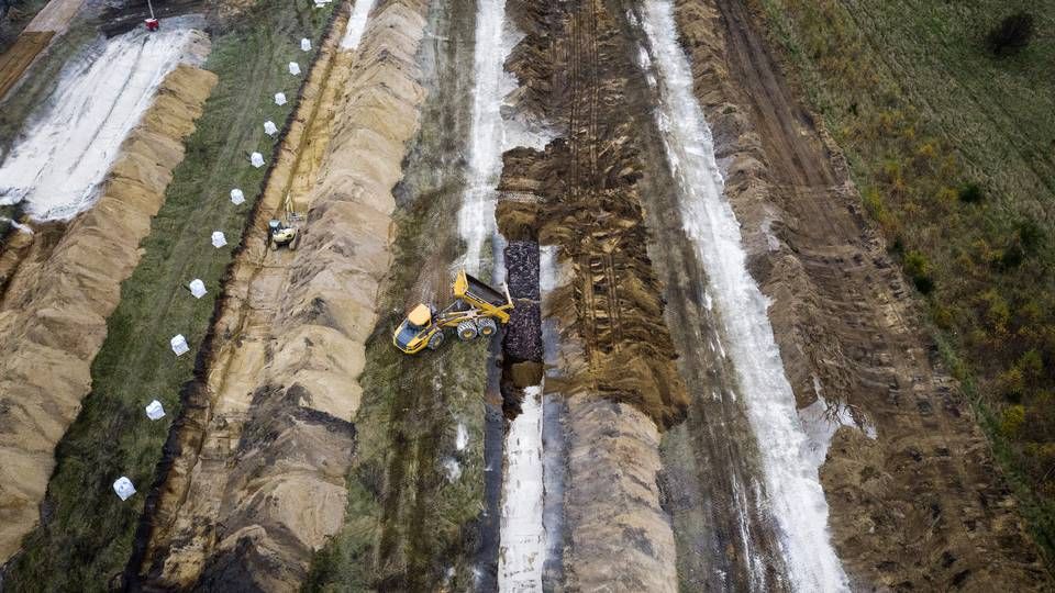 Massegrave til millioner af aflivede mink har skabt frygt for fremtidens drikkevand og skader på naturen. Her lægger myndighederne et lag kalk under og oven på de døde mink i et forsøg på at undgå forurening af omgivelserne. Nu vil Miljøstyrelsen sikre, at det sker helt efter bogen. | Foto: Casper Dalhoff/IND