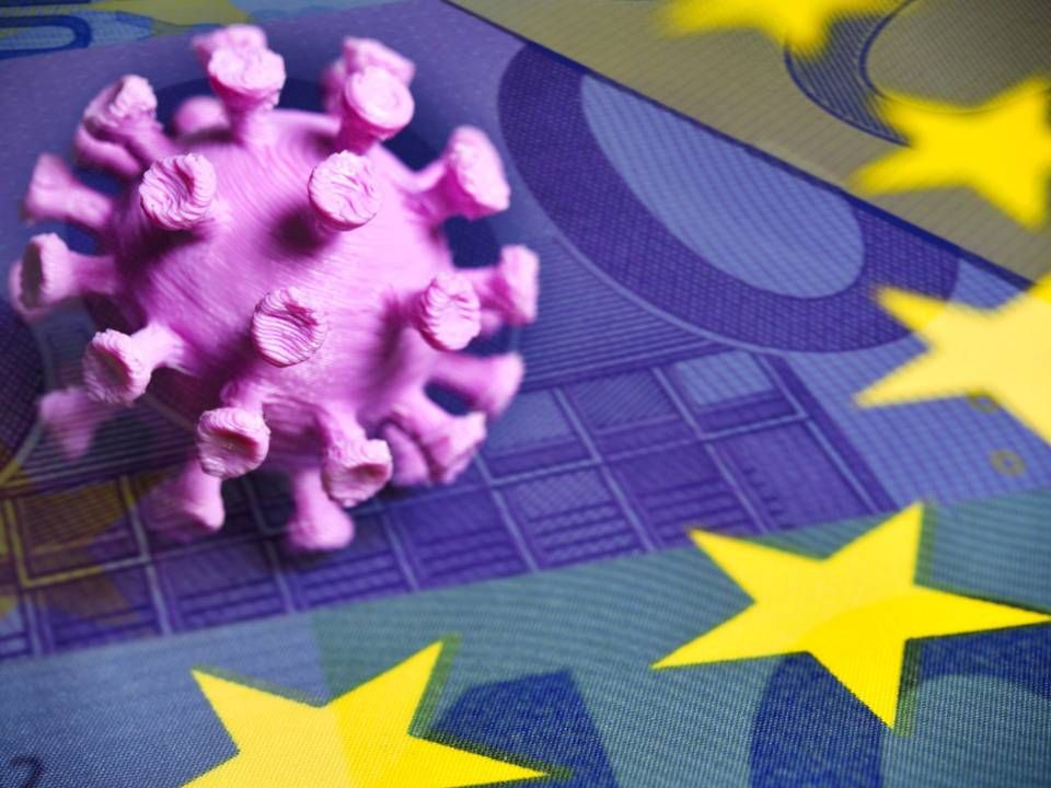 Coronavirus-Miniatur auf EU-Fahne mit Geldscheinen. | Foto: picture alliance/chromorange