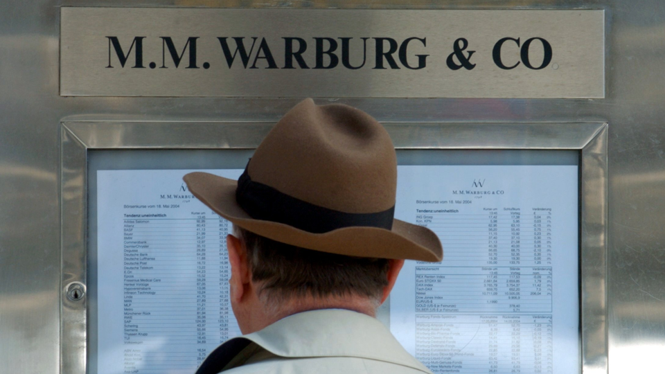 Ein Mann steht vor dem Aushang der Bank M.M. Warburg & Co | Foto: picture-alliance / dpa | Kay Nietfeld