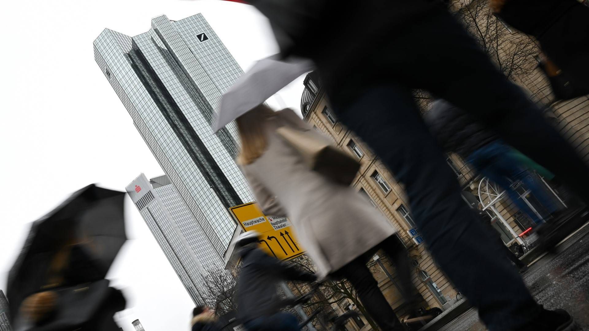 Passanten überqueren nahe der Zentrale der Deutschen Bank eine Straße. | Foto: picture alliance/dpa | Arne Dedert