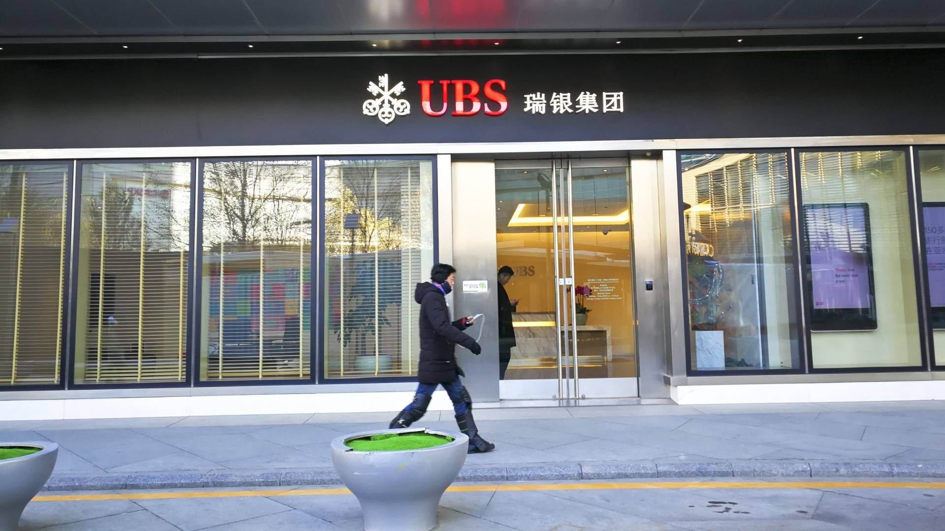 Ein Fußgänger vor einem Büro der UBS Group in Beijing | Foto: picture alliance/dpa