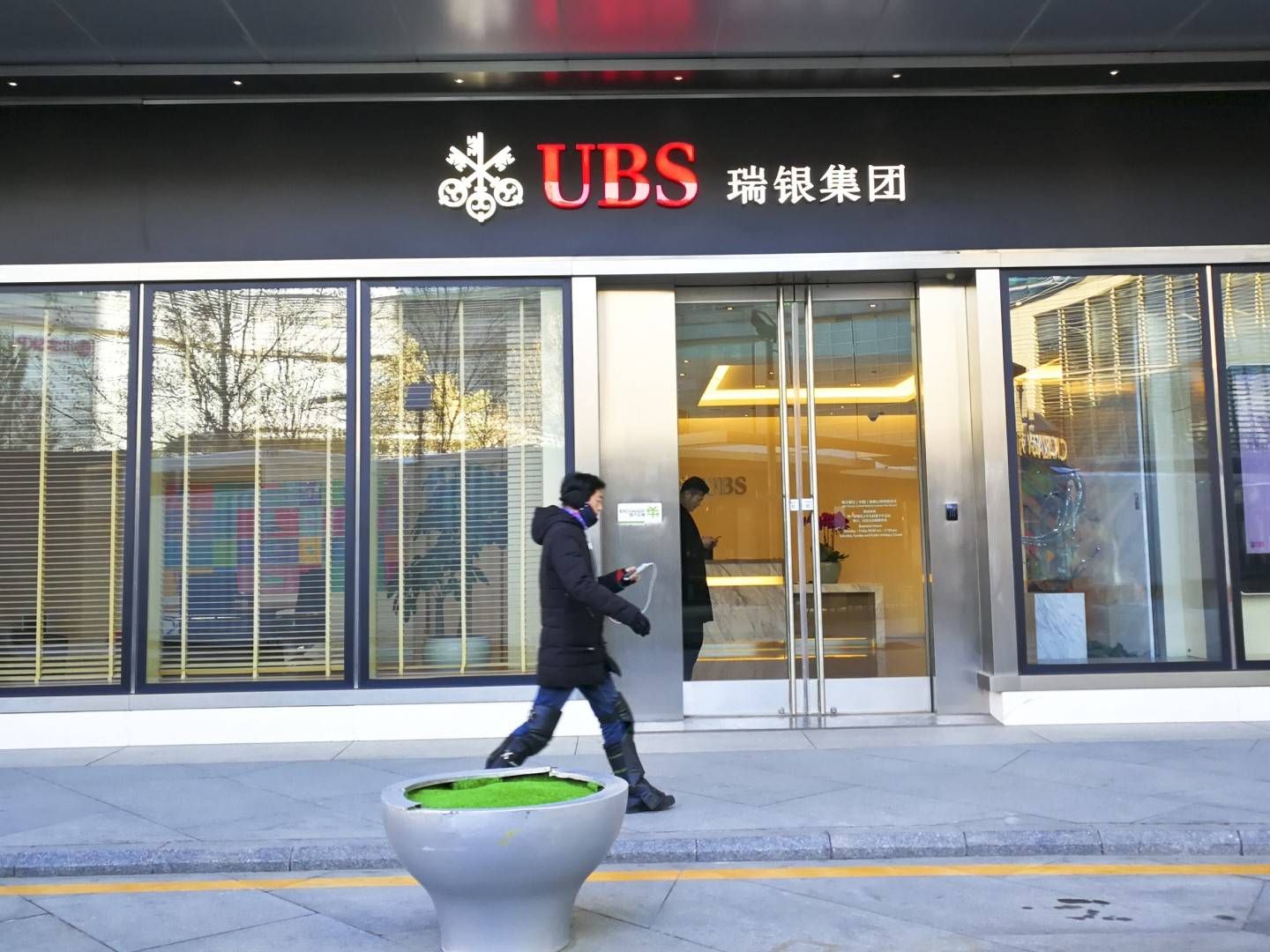 Ein Fußgänger vor einem Büro der UBS Group in Beijing | Foto: picture alliance/dpa