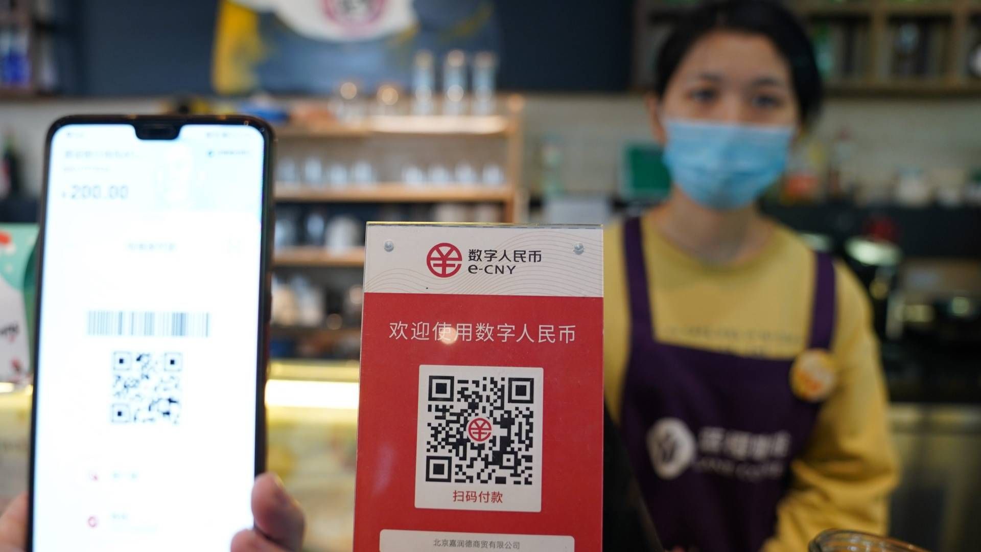Beschilderung des von der Zentralbank unterstützten digitalen Yuan (E-CNY) ist in einem Café während eines Pilotlaufs des chinesischen DCEP-Projekts (Digital Currency Electronic Payment) in Beijing zu sehen | Foto: picture alliance/dpa/MAXPPP