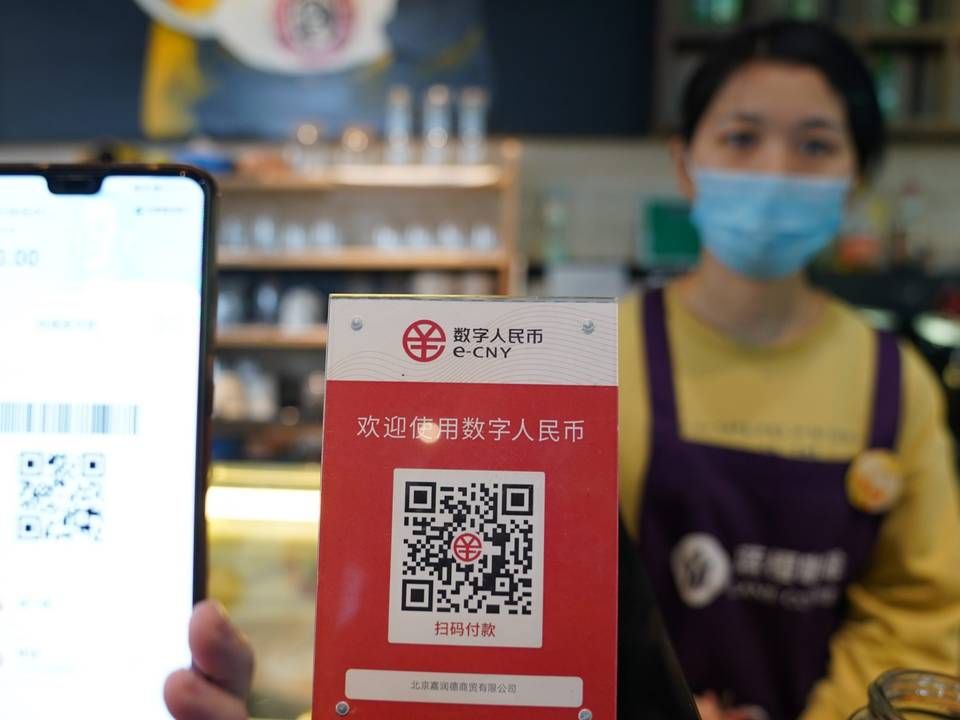 Beschilderung des von der Zentralbank unterstützten digitalen Yuan (E-CNY) ist in einem Café während eines Pilotlaufs des chinesischen DCEP-Projekts (Digital Currency Electronic Payment) in Beijing zu sehen | Foto: picture alliance/dpa/MAXPPP