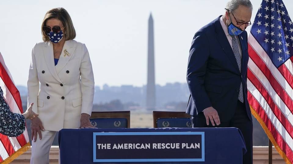 Formanden for Repræsentanternes Hus, demokraten Nancy Pelosi, og flertalslederen i Senatet, demokraten Chuck Schumer, underskriver hjælpepakken. Den sendes nu til præsident Bidens skrivebord. | Foto: DREW ANGERER/AFP / GETTY IMAGES NORTH AMERICA