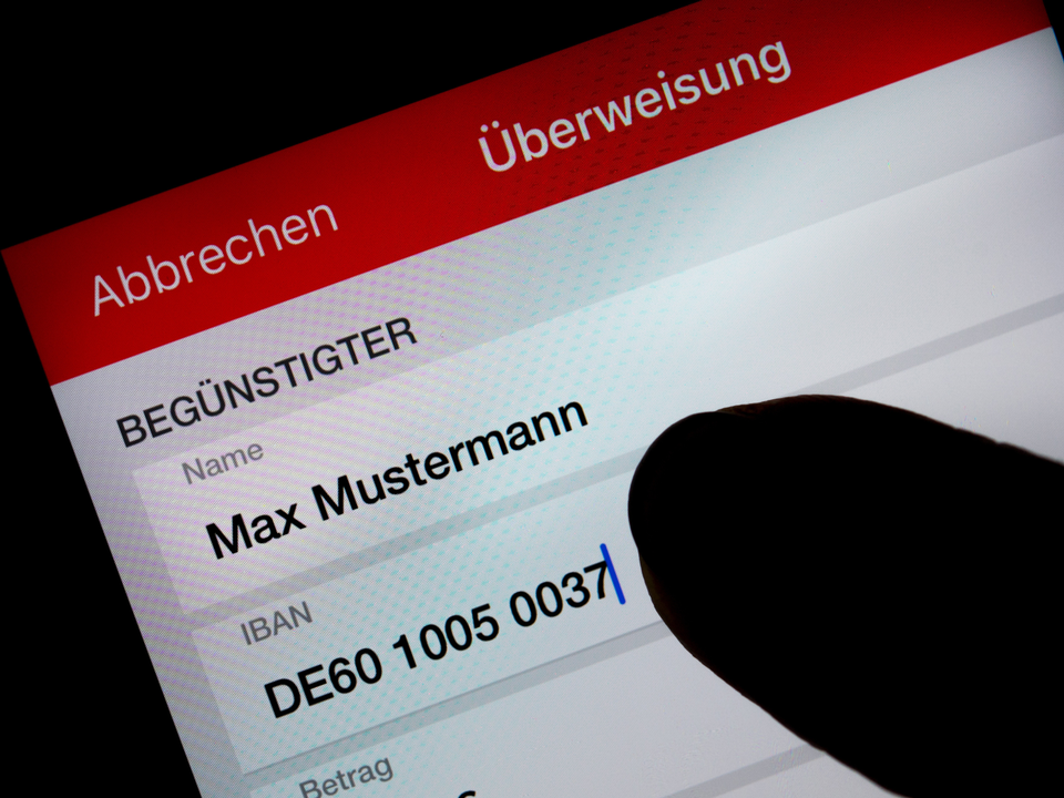 Eine Frau nutzt auf ihrem Smartphone eine App, um im Online-Banking eine SEPA-Überweisung zu veranlassen. | Foto: picture alliance/dpa | Monika Skolimowska
