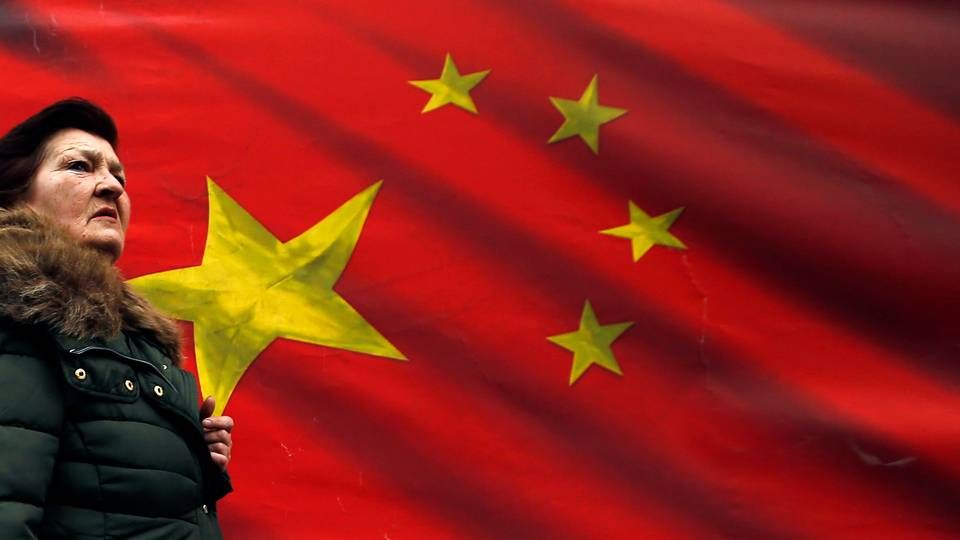 Gennem de senere år har Kina investeret massivt i kritisk infrastruktur i blandt andet Østeuropa og på Balkan. Her ses en serbisk kvinde gå forbi et kinesisk flag i Beograd i 2019. EU-Kommissionen går nu til kamp mod kinesisk statsstøtte på europæisk jord. | Foto: Darko Vojinovic/AP/Ritzau Scanpix