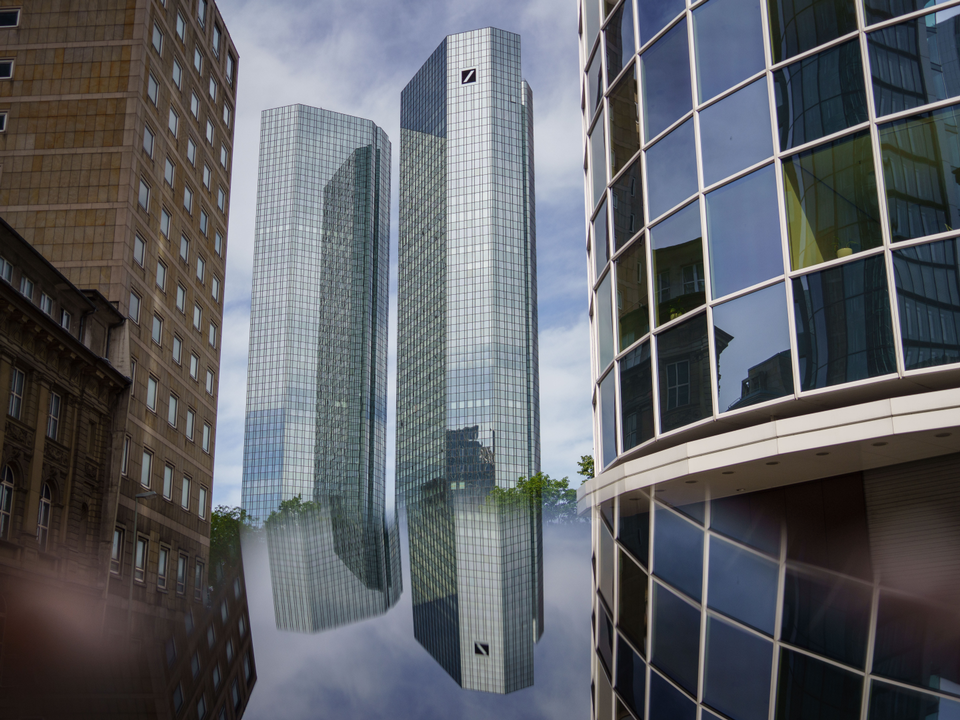 Die Doppeltürme der Zentrale der Deutschen Bank spiegeln sich im Bildschirm eines Smartphones. | Foto: picture alliance/dpa | Frank Rumpenhorst