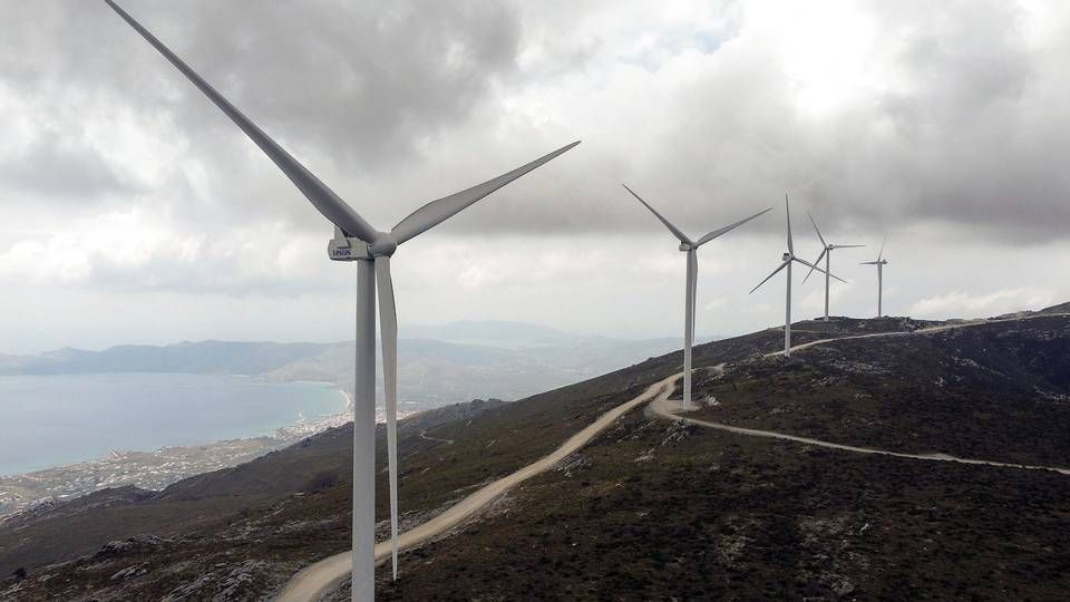 Wind turbines are seen on a mountain as the town of Karystos is seen in the background, on the island of Evia, Greece. | Photo: Alkis Konstantinidis/Reuters/Ritzau Scanpix