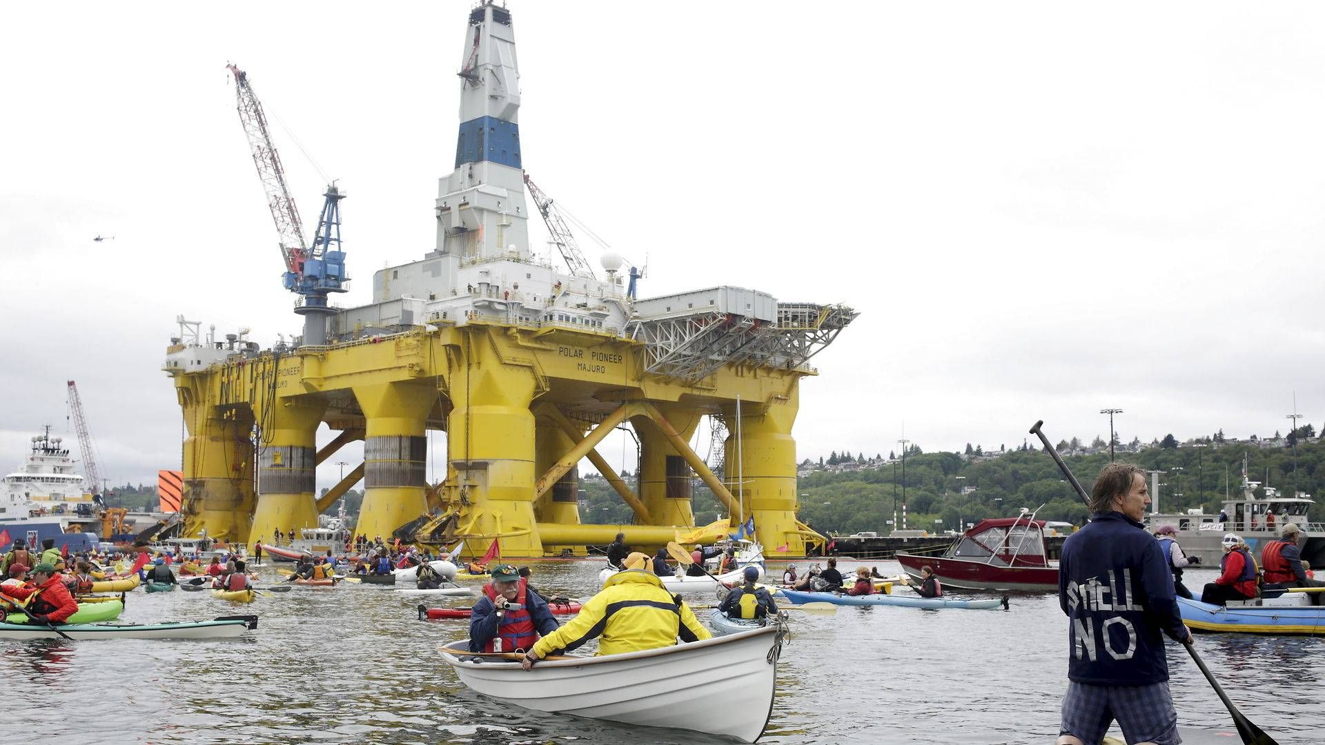 Demonstranter flokkes om Shells olierig Polar Pioneer ved havnen i Seattle. Fremover bliver klimakampene i højere grad taget i retten, hvis man spørger hos Greenpeace. | Foto: Jason Redmond/Reuters/Ritzau Scanpix
