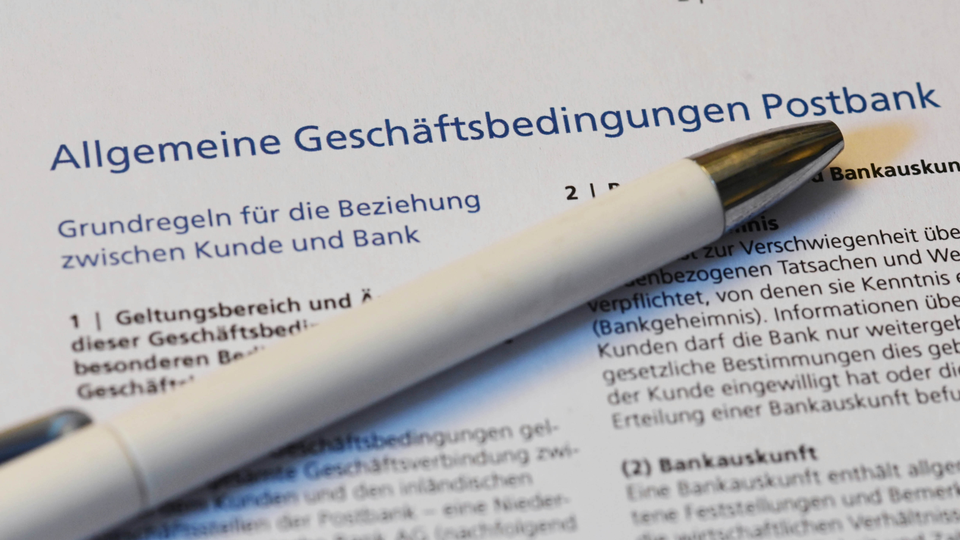 Ein Kugelschreiber liegt auf der ersten Seite der Allgemeine Geschäftsbedingungen (AGB) der Postbank. | Foto: picture alliance/dpa | Uli Deck