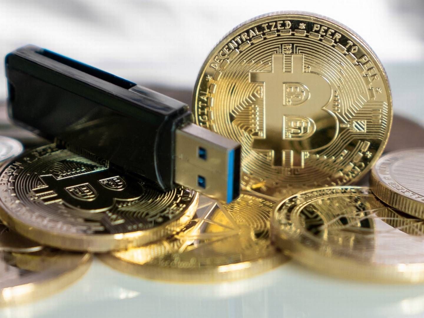 Bitcoin-Goldmünzen neben USB-Stick | Foto: picture alliance / Daniel Kalker | Daniel Kalker