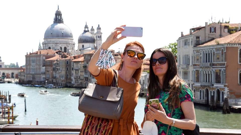 Nu kan de amerikanske turister vende tilbage til Venedig og andre turistmål i Europa. EU-landene har onsdag besluttet at ophæve de fleste rejserestriktioner, der har været gældende under coronakrisen, over for USA og fem andre lande. De to kvinder, der er i gang med en selfie på en af Venedigs broer, er dog næppe amerikanere, for lempelserne træder først i kraft om nogle dage. | Foto: Andrea Pattaro/AFP/Ritzau Scanpix
