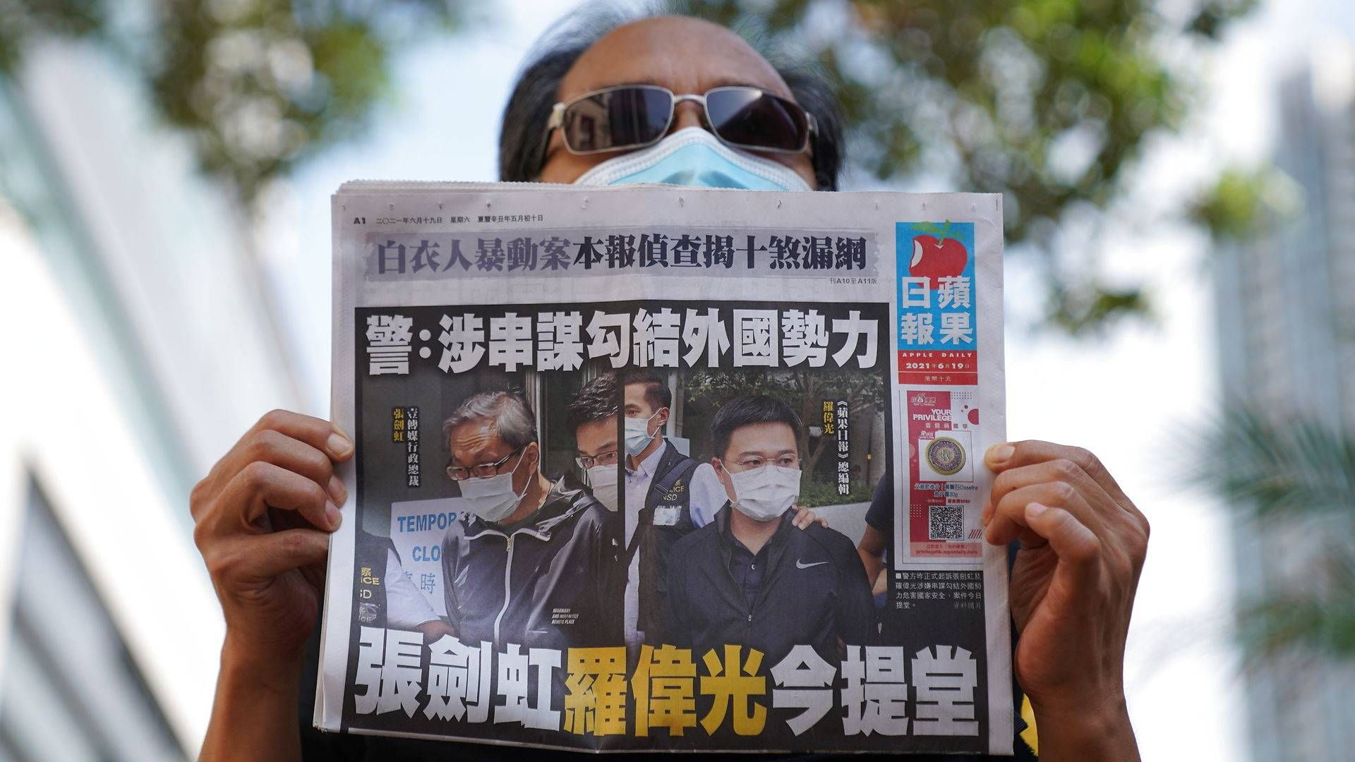 En demostrant holder et eksemplar af Apple Daily op, hvor anholdelsen af avisens mediechefer er på forsiden. | Foto: Lam Yik/Reuters/Ritzau Scanpix