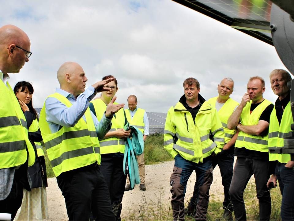Knud Erik Andersen (blå skjorte, tv.) fortæller om de særlige sensorer, som gør det muligt for solcellepanelerne at følge solen. | Foto: Daniel Skinbjerg / Watch Medier