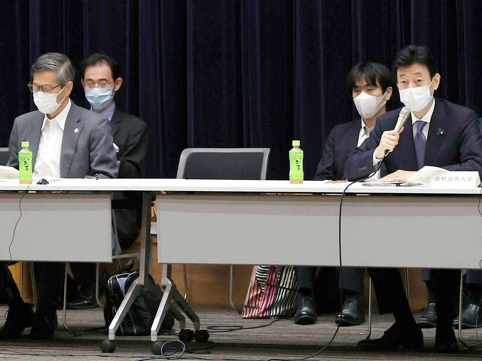 Japans økonomiminister, Yasutoshi Nishimura, med mikrofonen i hånden under et pressemøde om corona-situationen i landet. | Foto: AP/Ritzau Scanpix