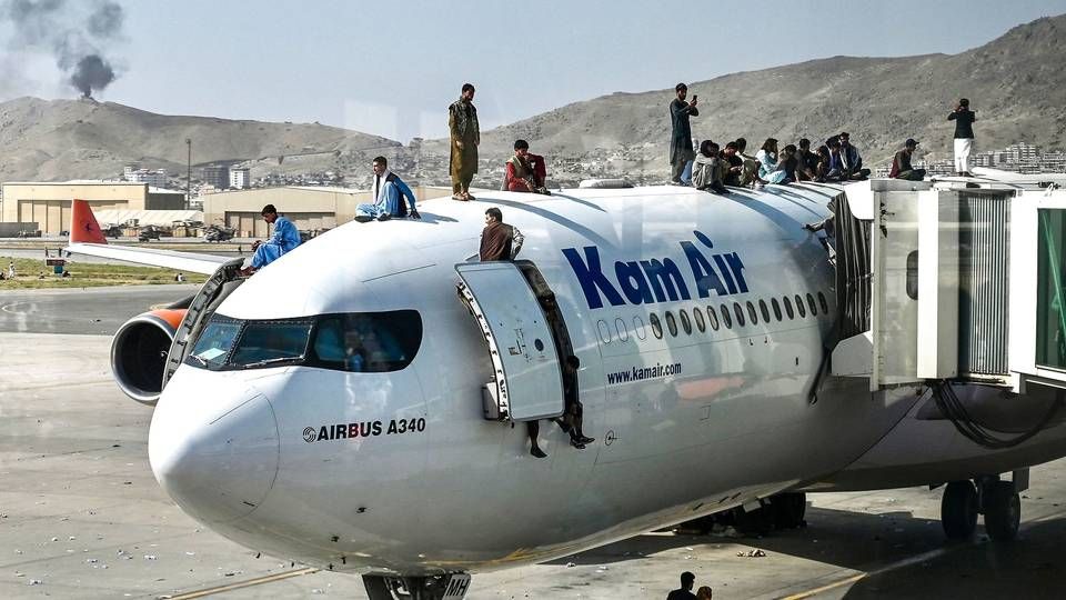 Afghanere klatrer op på et fly i lufthavnen i Kabul 16. august 2021, hvor mange forsøgte at flygte fra landet efter Talibans indtagelse af hovedtstaden. | Foto: Wakil Kohsar/AFP/Ritzau Scanpix
