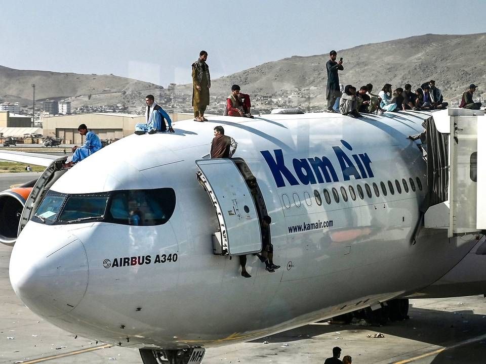 Afghanere klatrer op på et fly i lufthavnen i Kabul 16. august 2021, hvor mange forsøgte at flygte fra landet efter Talibans indtagelse af hovedtstaden. | Foto: Wakil Kohsar/AFP/Ritzau Scanpix