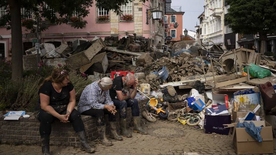 Frivillige i Bad Neuenahr-Ahrweiler tar en pause blant vrakgodset etter sommerens flom i Tyskland. | Foto: Bram Janssen / AP / NTB