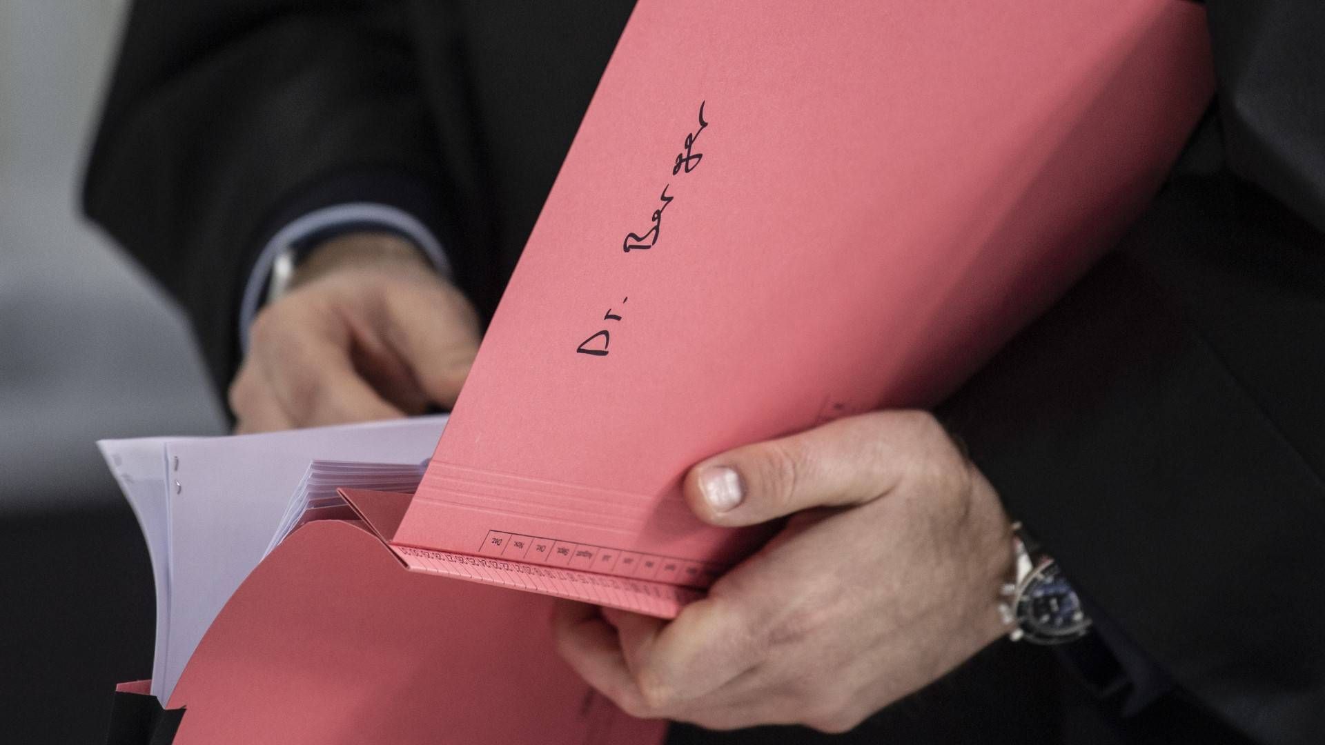 Ein Rechtsanwalt hält im Gerichtssaal eine Akte mit der Aufschrift «Dr. Berger» in der Hand. | Foto: picture alliance/dpa | Boris Roessler