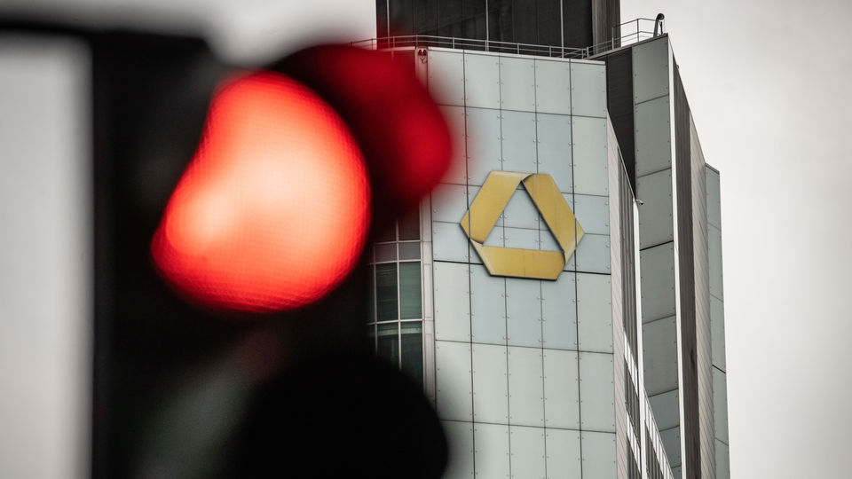 Eine Ampel steht auf Rot vor dem Logo an der Zentrale der Commerzbank. Auf | Foto: picture alliance/dpa | Frank Rumpenhorst