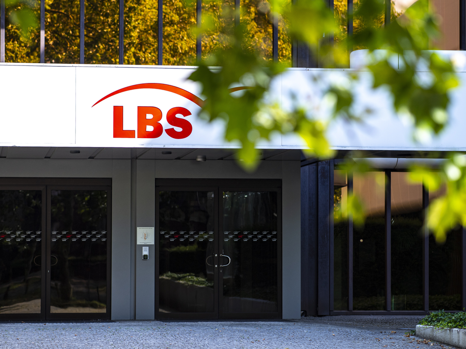 Das Logo der LBS (Landesbausparkasse) hängt über dem Haupteingang der LBS West Zentrale in Münster. | Foto: picture alliance/dpa | Guido Kirchner