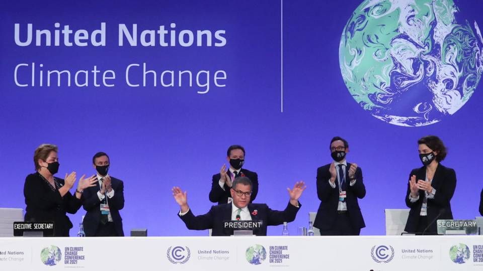 COP26-formand Alok Sharma rækker hænderne ud, mens han modtager bifald ved afslutningen af klimamødet i Glasgow lørdag aften. Han siger selv, at han ville ønske, at han havde kunnet bevare den oprindelige, skrappere tekst om udfasning af kulkraft - i stedet for nedtrapning, som teksten endte med at nævne. | Foto: Yves Herman/Reuters