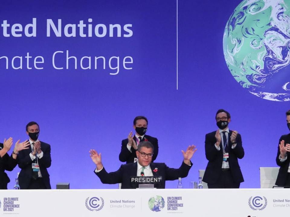 COP26-formand Alok Sharma rækker hænderne ud, mens han modtager bifald ved afslutningen af klimamødet i Glasgow lørdag aften. Han siger selv, at han ville ønske, at han havde kunnet bevare den oprindelige, skrappere tekst om udfasning af kulkraft - i stedet for nedtrapning, som teksten endte med at nævne. | Foto: Yves Herman/Reuters