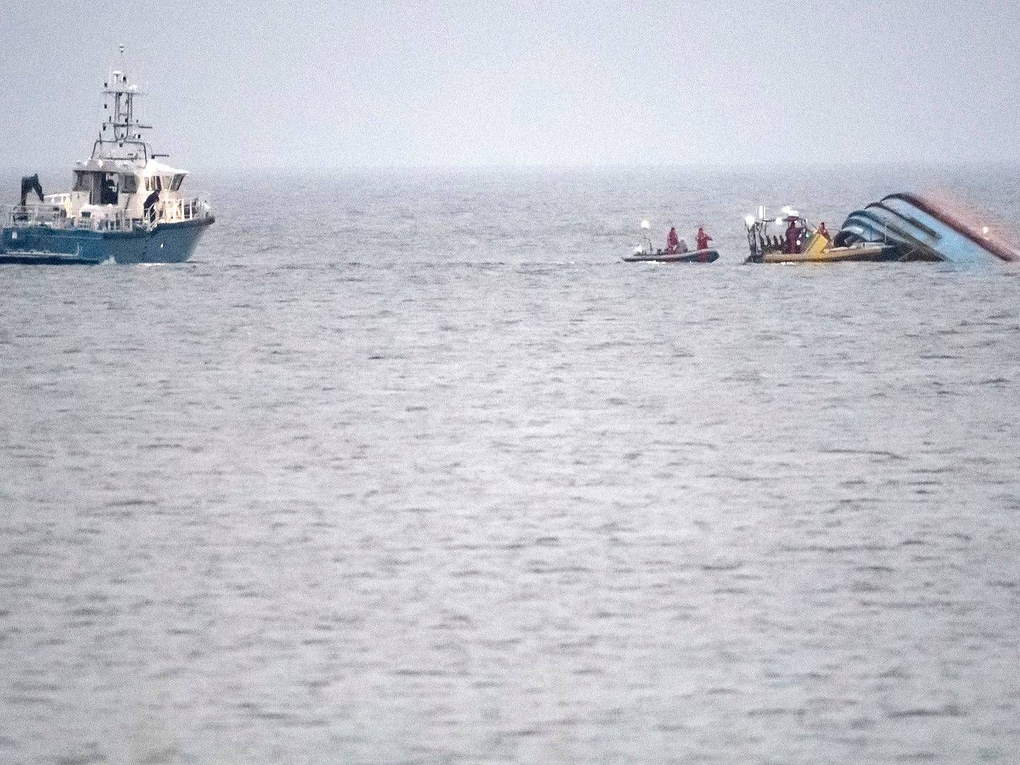 Den svenske kystvagt ved "Karin Høj", der er begyndt at synke og lække olie. Det kæntrede danske skib er blevet bugseret mod land og ligger nu ud for stranden ved Tobisvik nord for Simrishamn. | Foto: Johan Nilsson/TT/Ritzau Scanpix