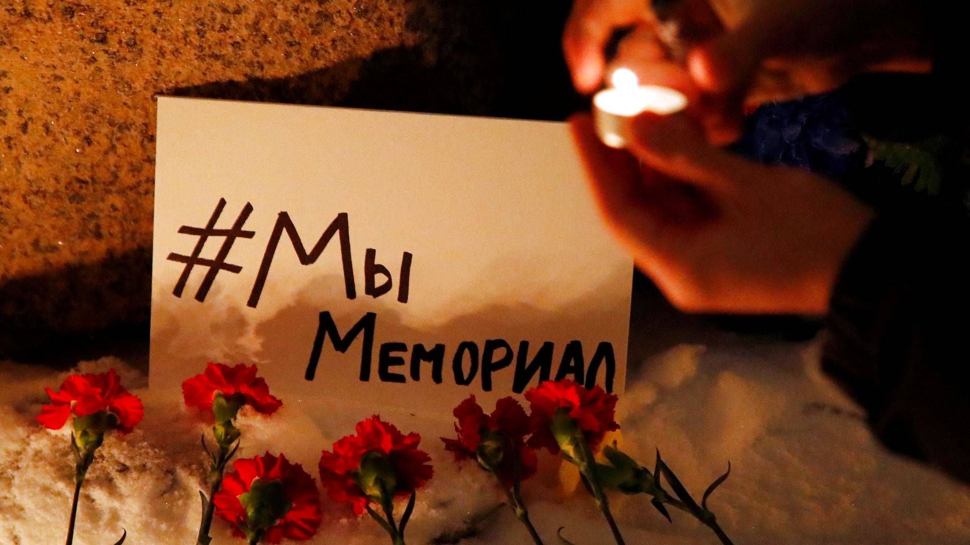 Tirsdag aften tænder Memorials støtter lys og lægger blomster ved Solovetskij-stenen i Moskva, der er et mindesmærke for ofrene for politisk undertrykkelse i Sovjetunionen. "#Vi er Memorial", lyder teksten på kortet. | Foto: Anton Vaganov/Reuters/Ritzau Scanpix
