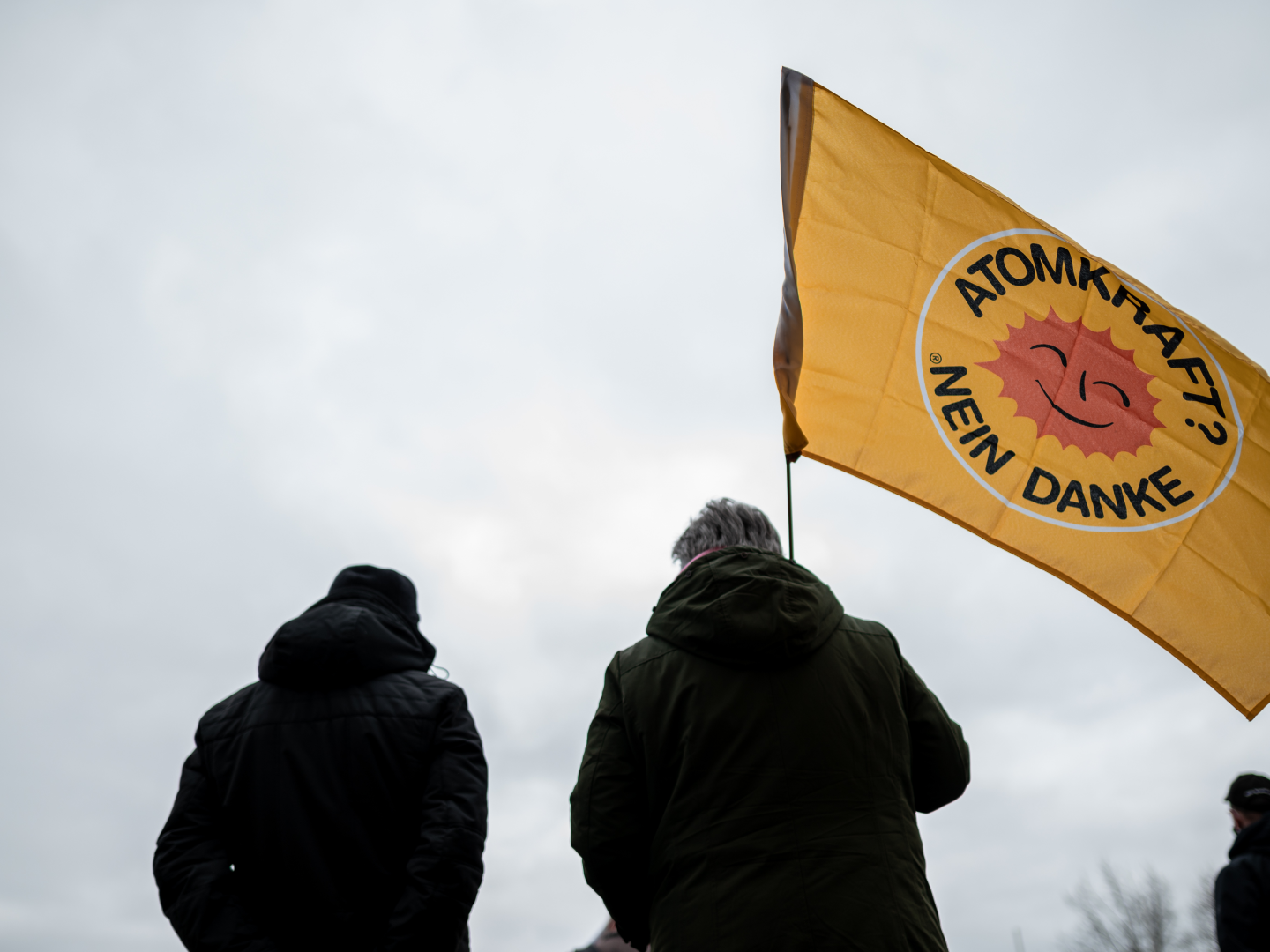 Demonstrant steht mit einer Fahne, auf der "Atomkraft? Nein danke" steht, vor der Anlage in Gronau. | Foto: picture alliance/dpa | Fabian Strauch