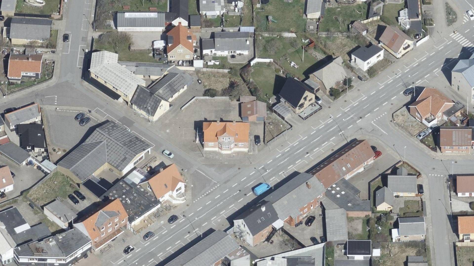 Den tidligere politistation i havnebyen Hirtshals ses i midten af billedet. Snart erstattes den og otte omkringliggende ejendomme af en Rema 1000. | Foto: Styrelsen for Dataforsyning og Effektivisering
