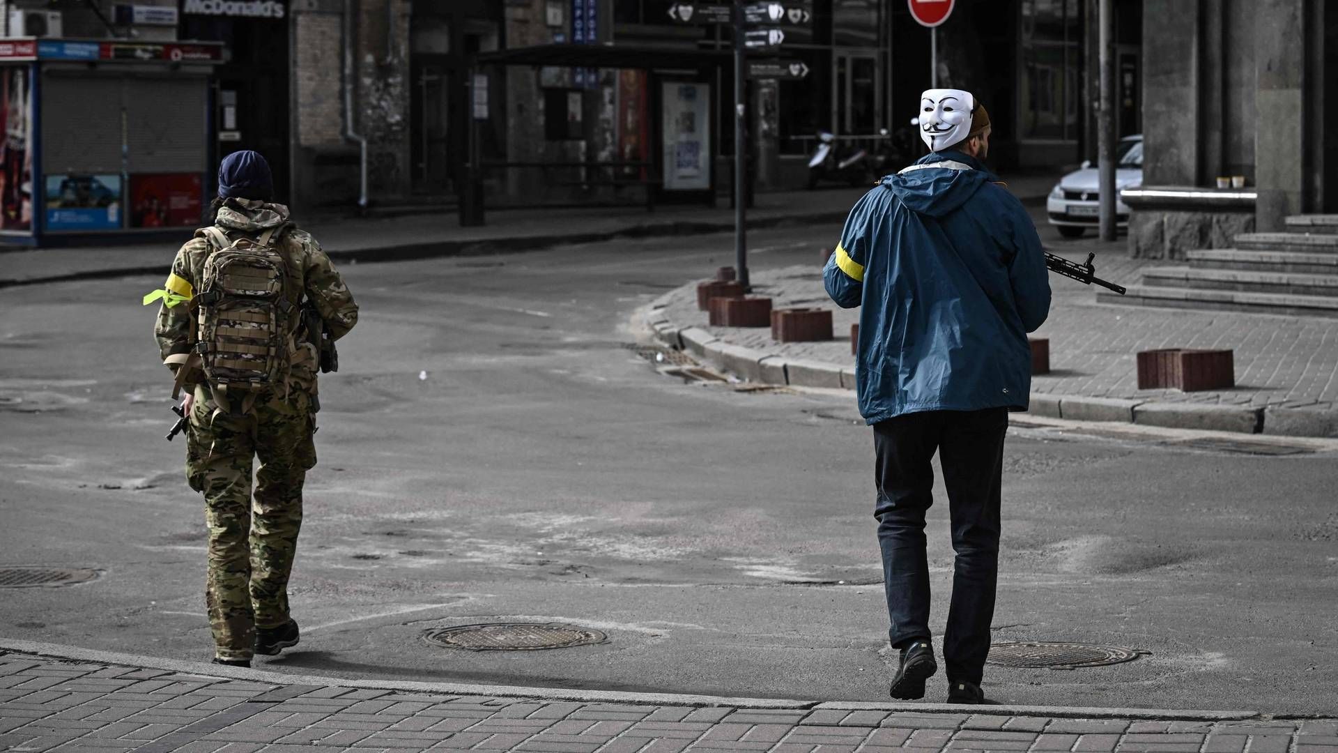 En ukrainsk soldat patruljerer i Kyiv iført en Guy Fawkes-maske, som ligeledes er kendetegnet for hackerbevægelsen Anonymous. | Foto: ARIS MESSINIS/AFP / AFP