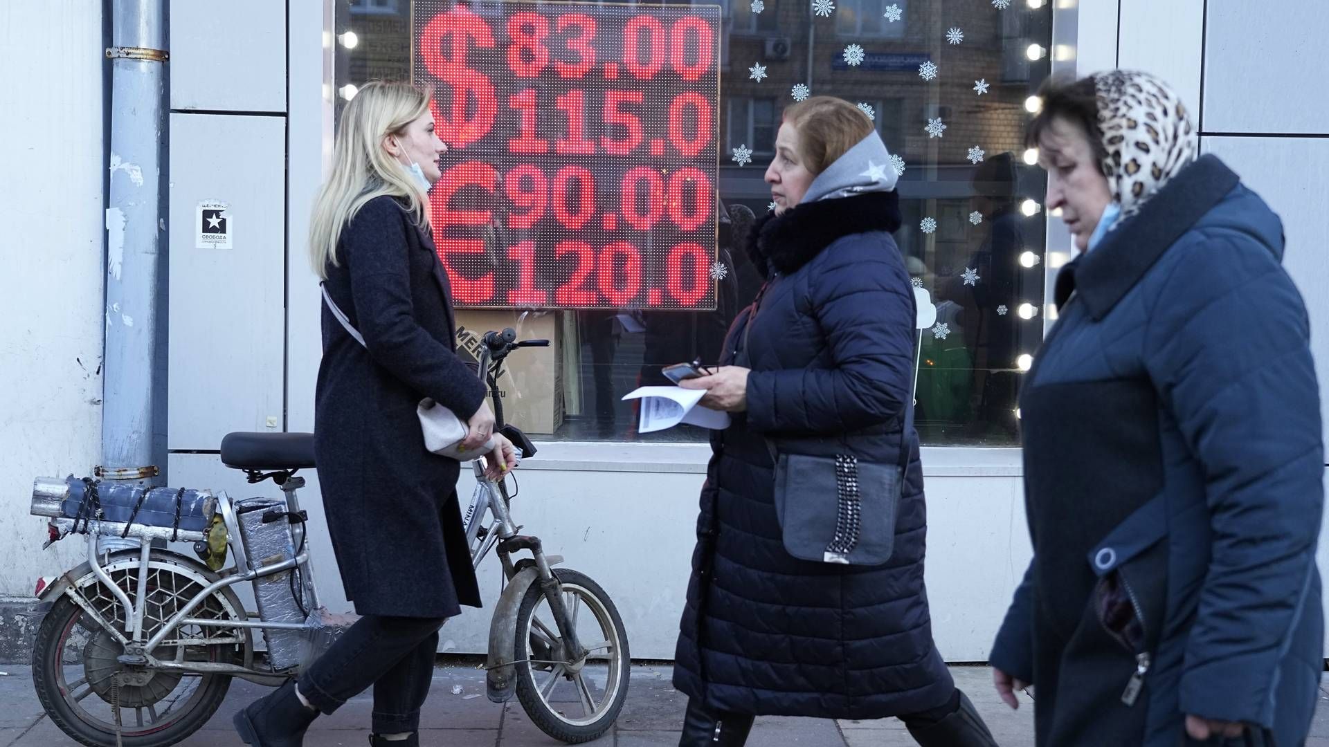 Folk går forbi en valutavekslingskontorskjerm som viser valutakursene fra amerikanske dollar og euro til russiske rubler i Moskva sentrum, 28. februar 2022. | Foto: Pavel Golovkin / AP