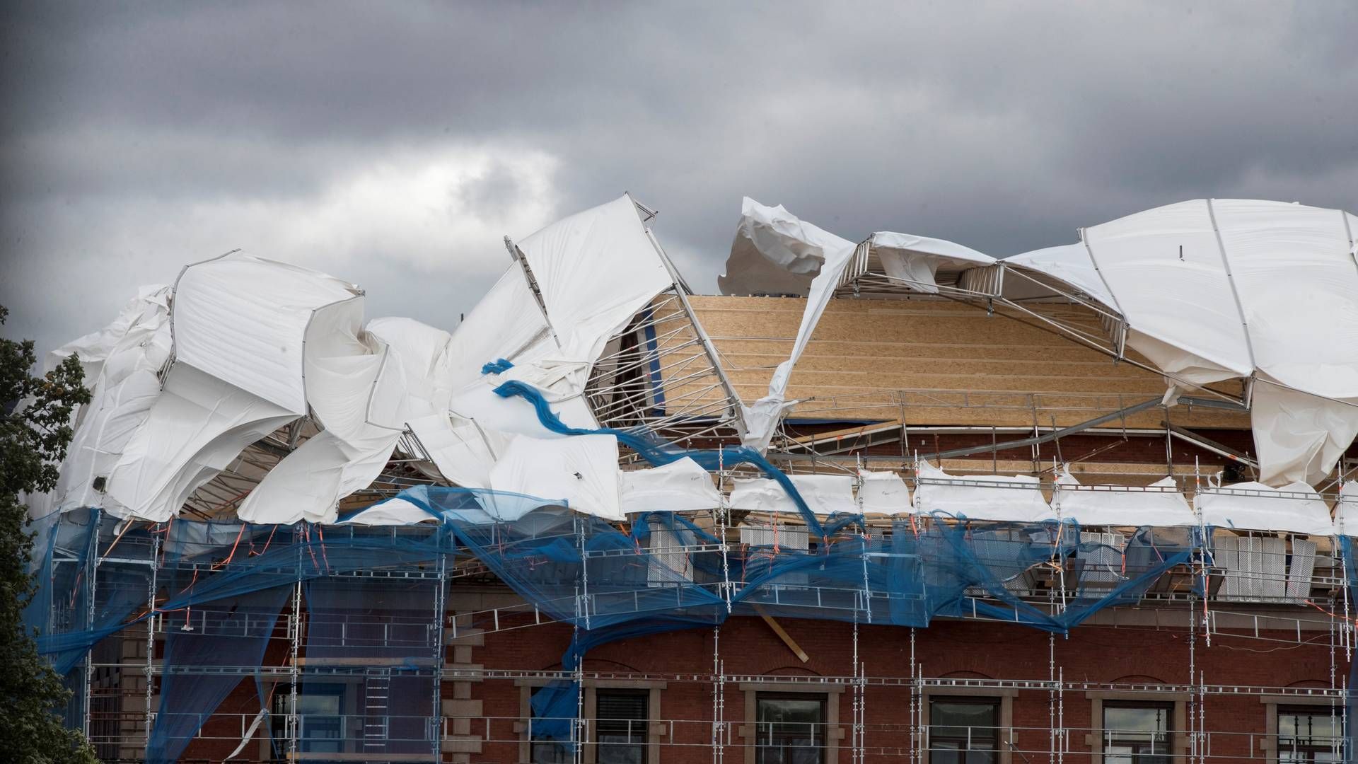 VÆRET KOSTER: Ekstremvær og mer fuktig vær kan skade eiendommer. Her har vinden tatt tak i stillaser rundt Tollboden i Oslo i 2018. | Foto: Terje Pedersen / NTB