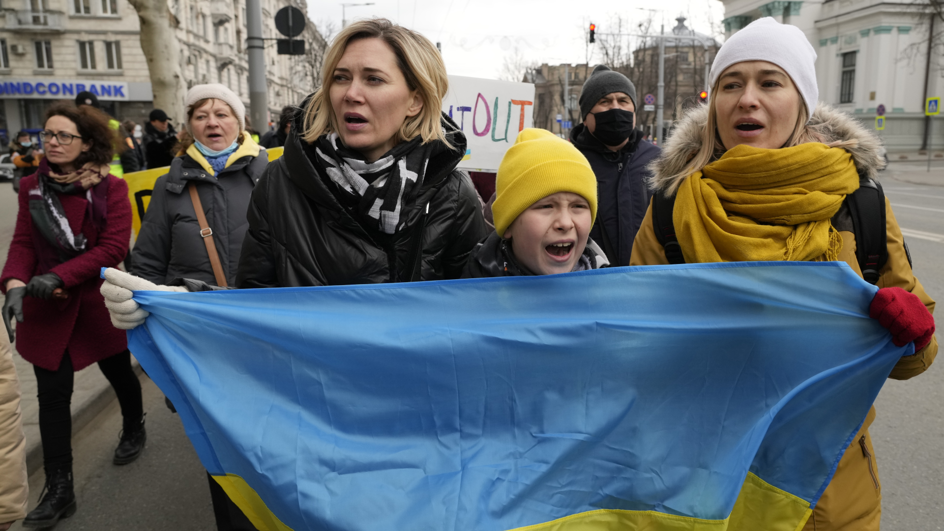 Ukrainske flyktninger holder et ukrainsk flagg under en markering av kvinnedagen i Moldovas hovedstad Chisinau tirsdag formiddag. | Foto: Sergei Grits / AP Photo