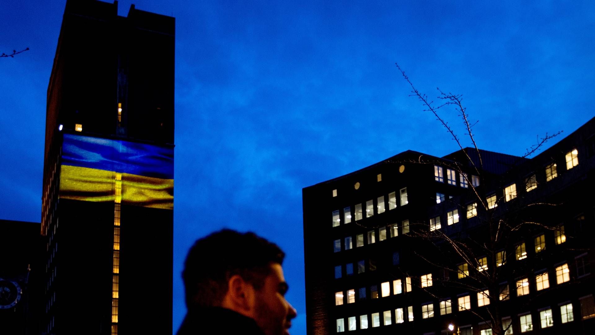 FARGET: Her er Oslo rådhus lyssatt med Ukrainas blå og gule flagg, som i likhet med mange andre bygg verden over har ønsket å gjøre dette for å støtte landet etter den russiske invasjonen. Krigen som pågår for fullt på bakken skaper også store implikasjoner for verdensøkonomien, som Malling & Co skriver om i sin siste rapport. | Foto: Javad Parsa, NTB