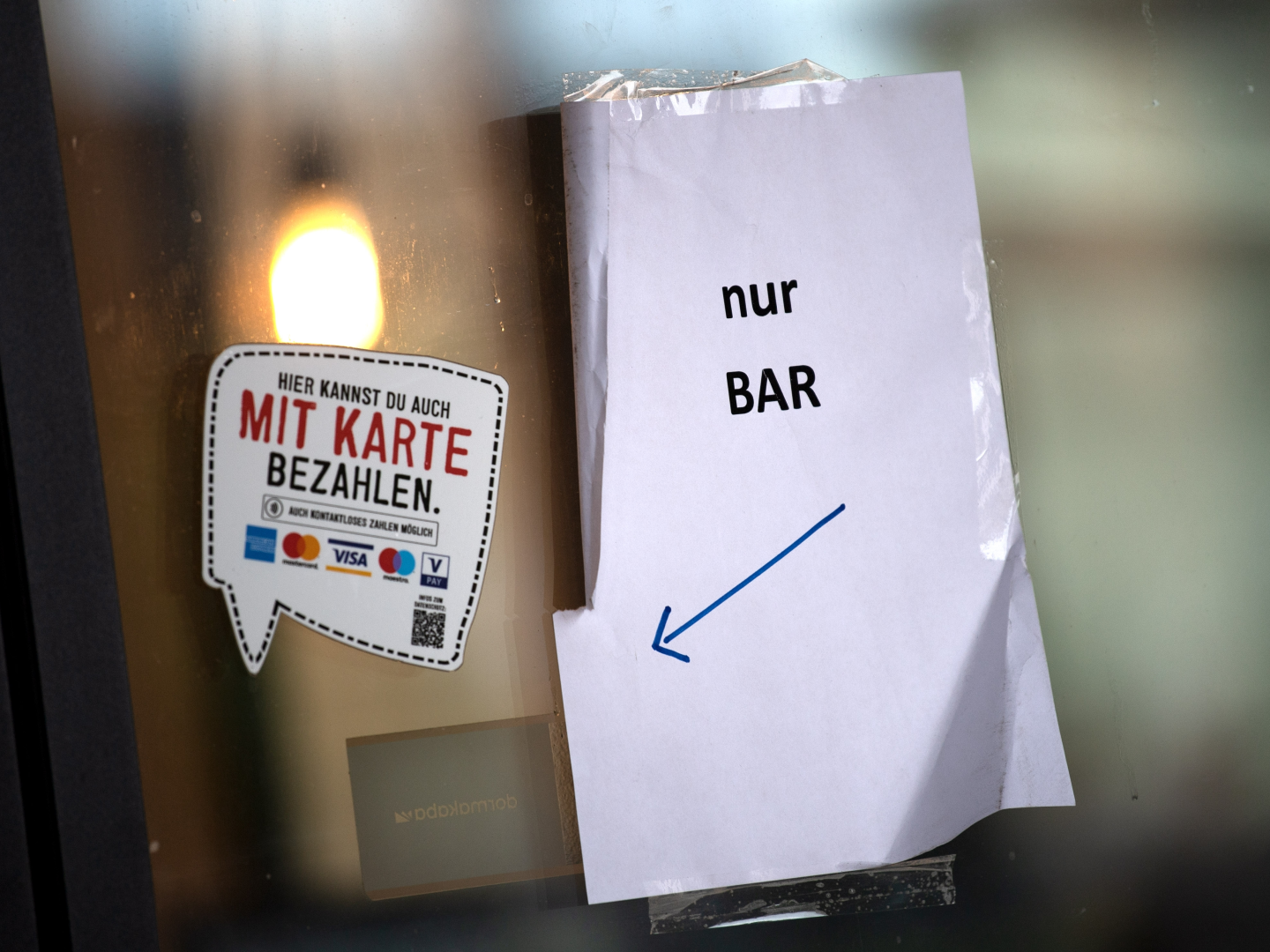 "Nur Bar" steht auf einem Schild am Eingang eines Geschäfts. | Foto: picture alliance/dpa | Sina Schuldt