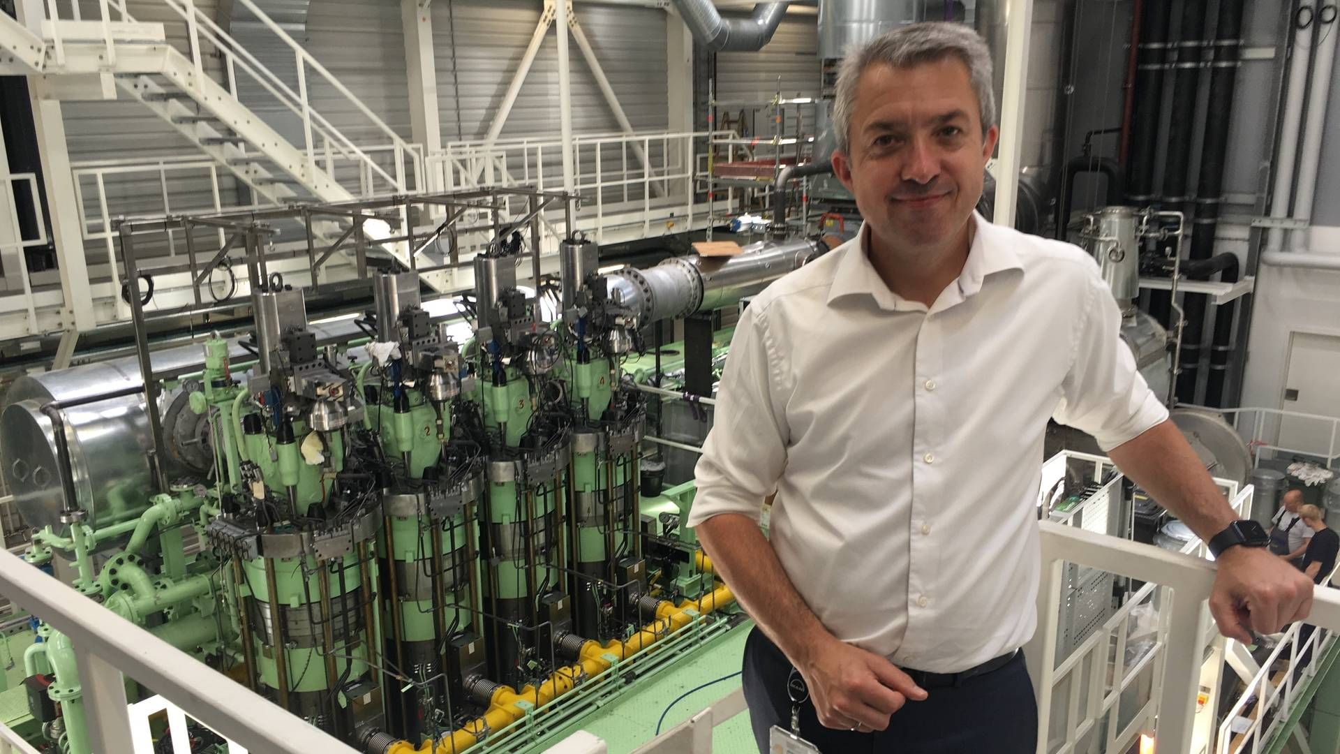 Brian Østergaard Sørensen, der er udviklingsdirektør for totaktsmotorer hos MAN Energy Solutions, foran en ny testmotor, som MAN skal bruge i arbejdet med at udvikle skibsmotorer. | Foto: ShippingWatch