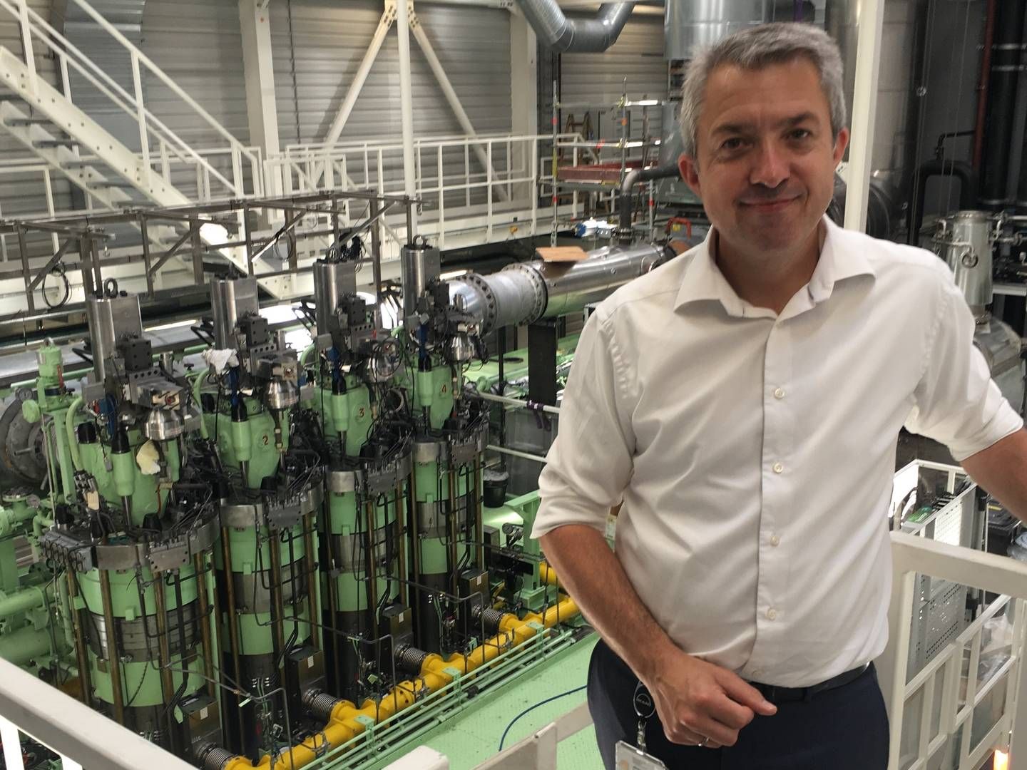 Brian Østergaard Sørensen, head of R&D for two-stroke engines at MAN, in front of a new test engine, which MAN will use in the development of ship engines. | Photo: ShippingWatch