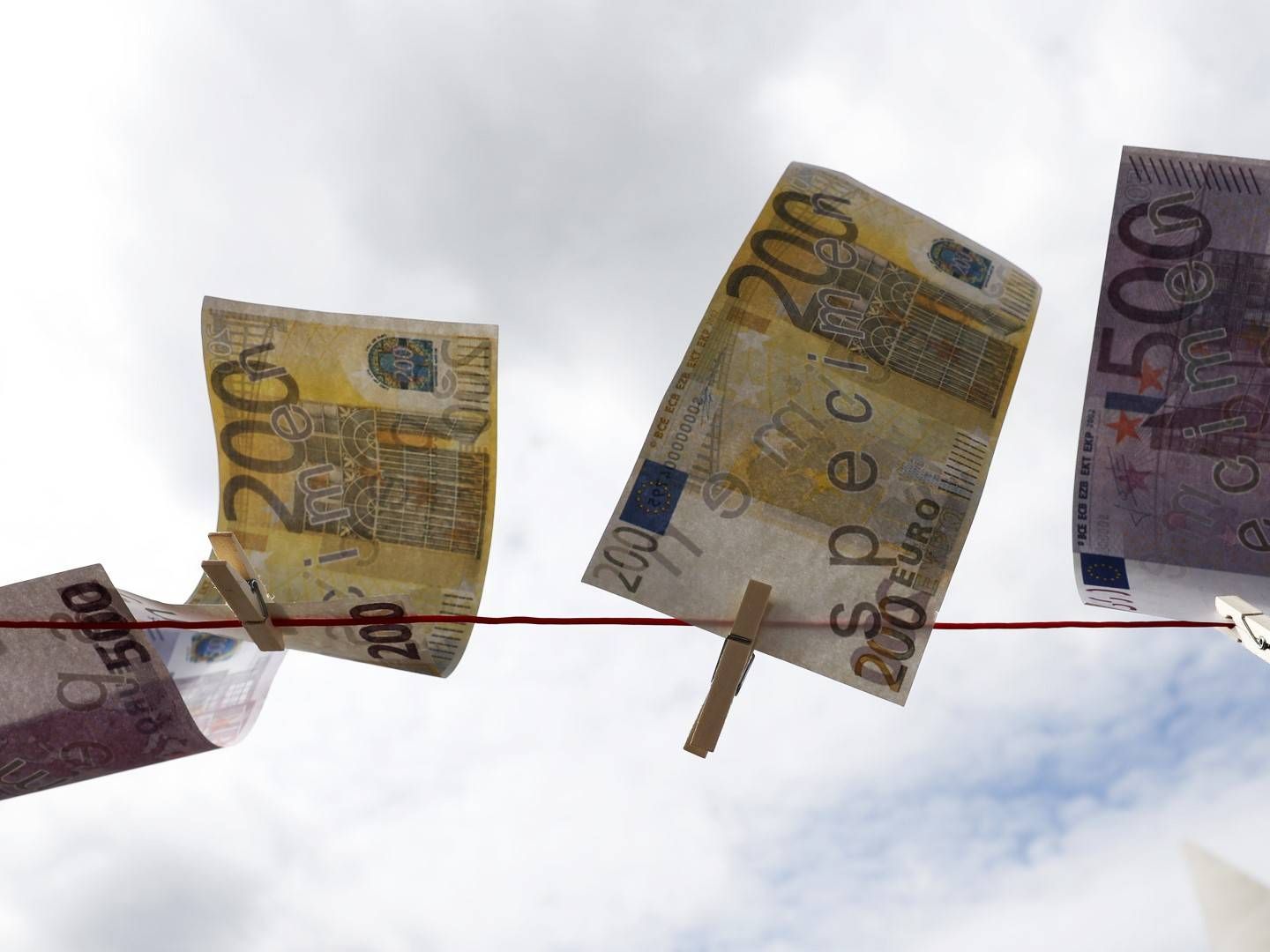 Gefälschte Euro-Banknoten hängen während einer Protestaktion gegen Geldwäsche vor den Parlamentsbüros in Berlin an einer Wäscheleine, | Foto: picture alliance/EPA | FELIPE TRUEBA