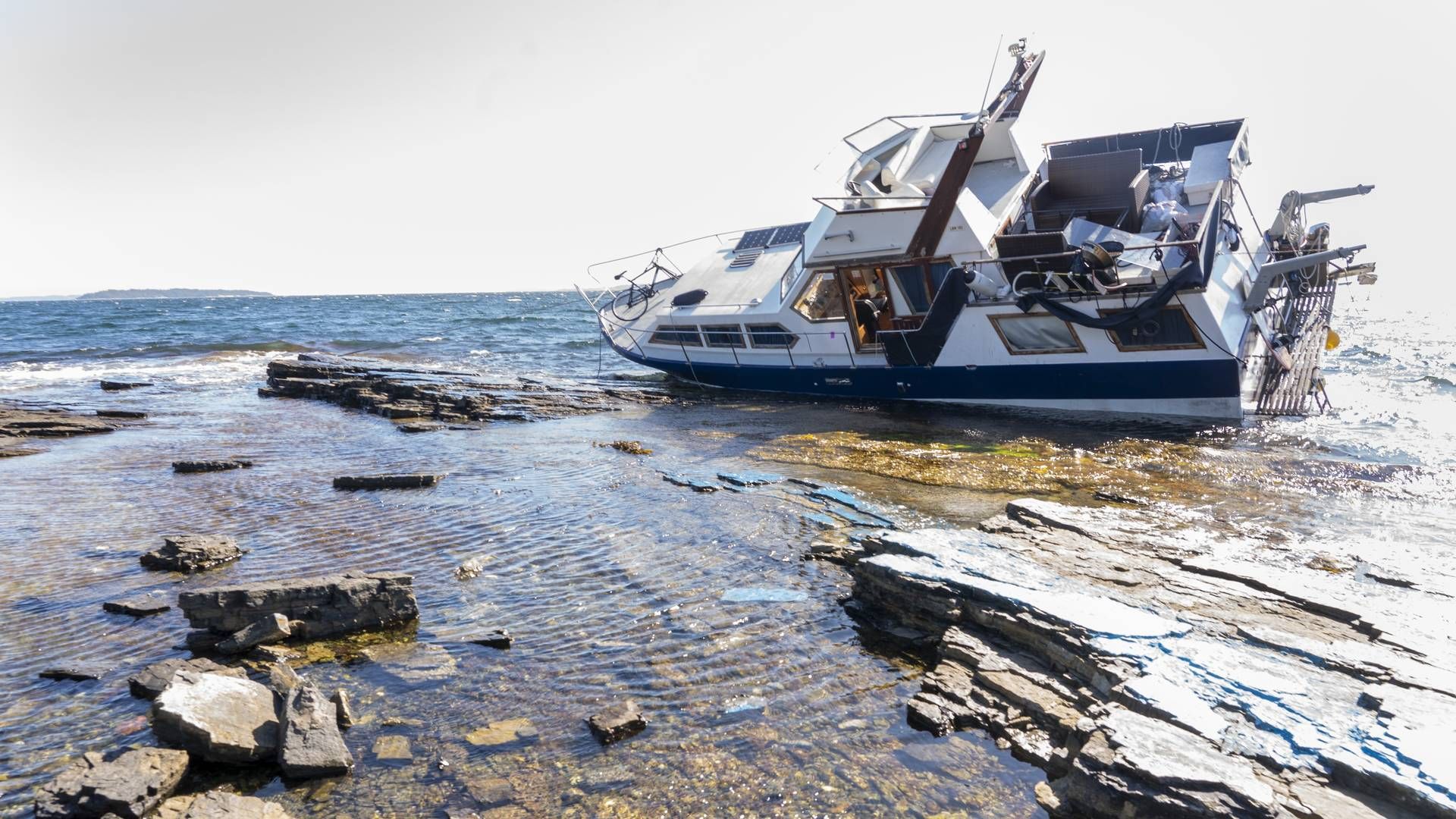 En båt har gått på grunn ved Skjøttelvik Asker i midten av august 2022. Politiet mistenker at fører var ruspåvirket. Båten slår mot stenene langs land og det er fare for at båten kan begynne å lekke. | Foto: Terje Pedersen / NTB