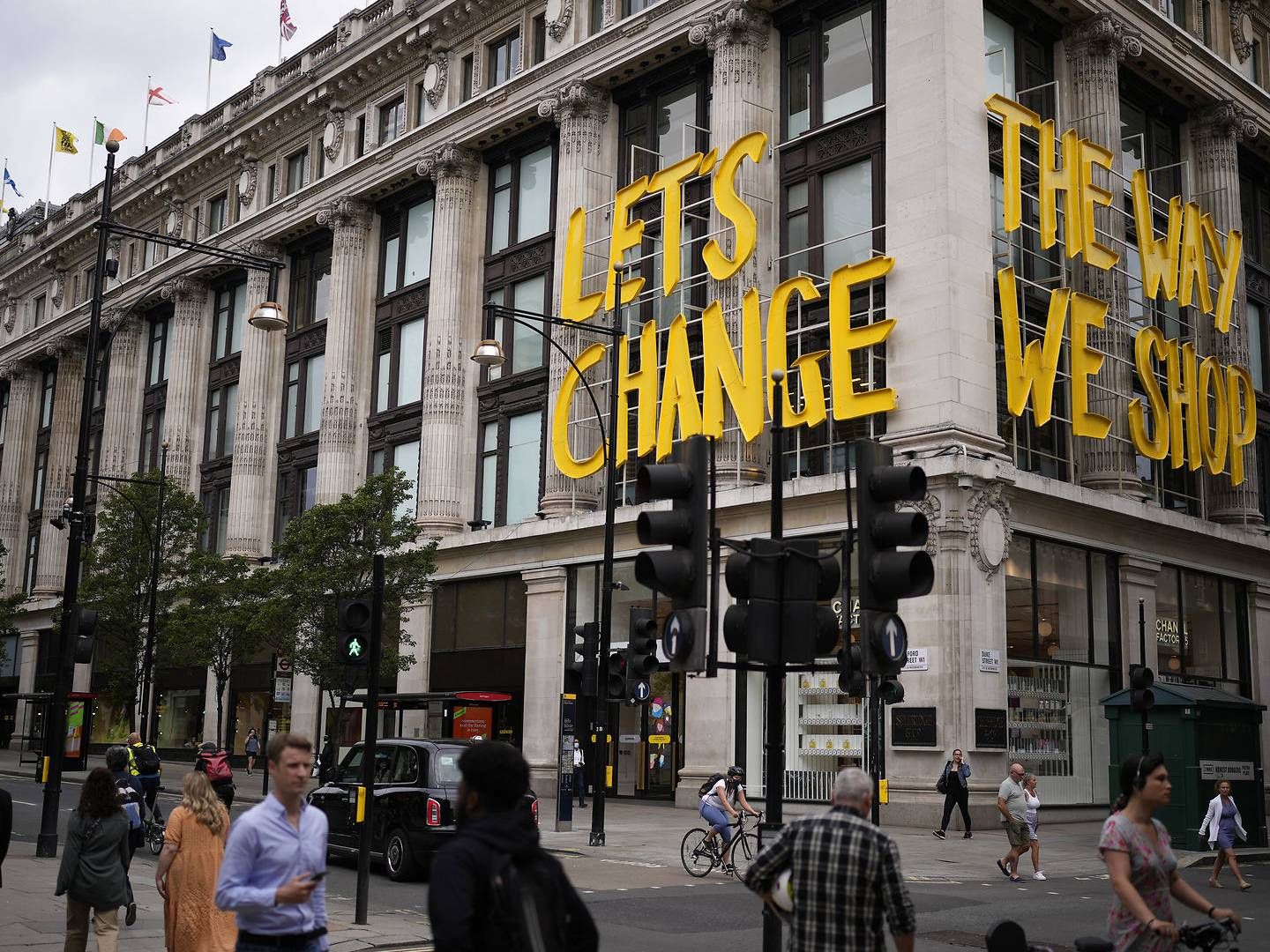 "Lad os ændre måden, vi shopper på" står bøjet i neon på facaden af et af Selfridges' stormagasiner. | Foto: Matt DunhamAPRitzau Scanpix/AP