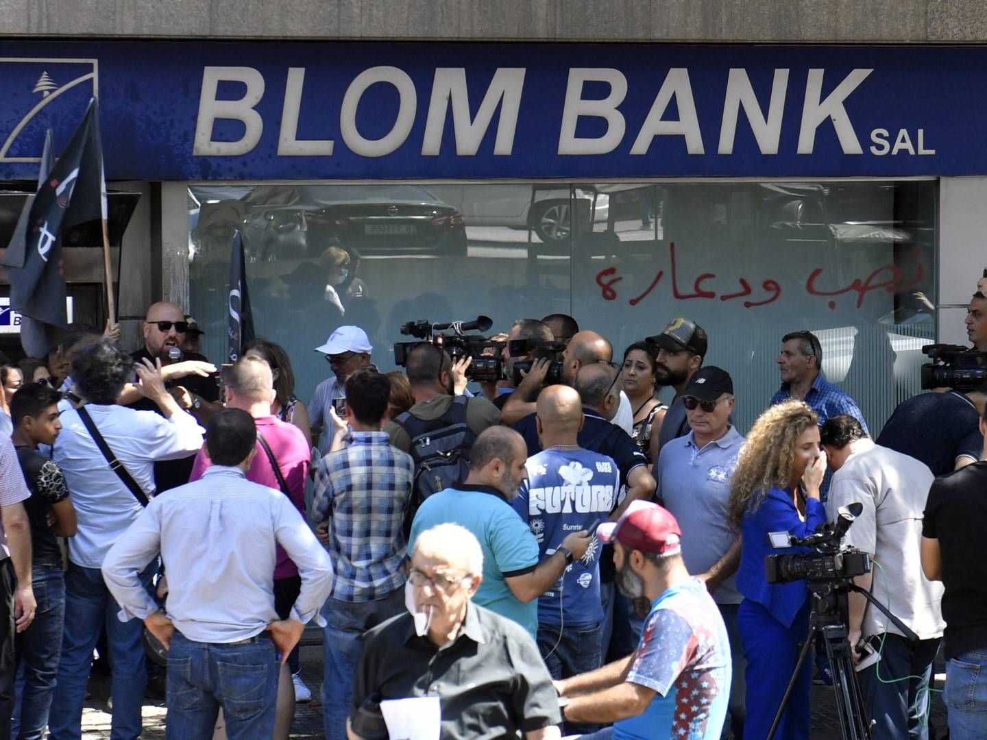 Kunden der libanesischen Blom Bank protestieren vor der filaiel, während im Inneren der Bank eine Geiselnahme stattfindet. | Foto: picture alliance / EPA | WAEL HAMZEH