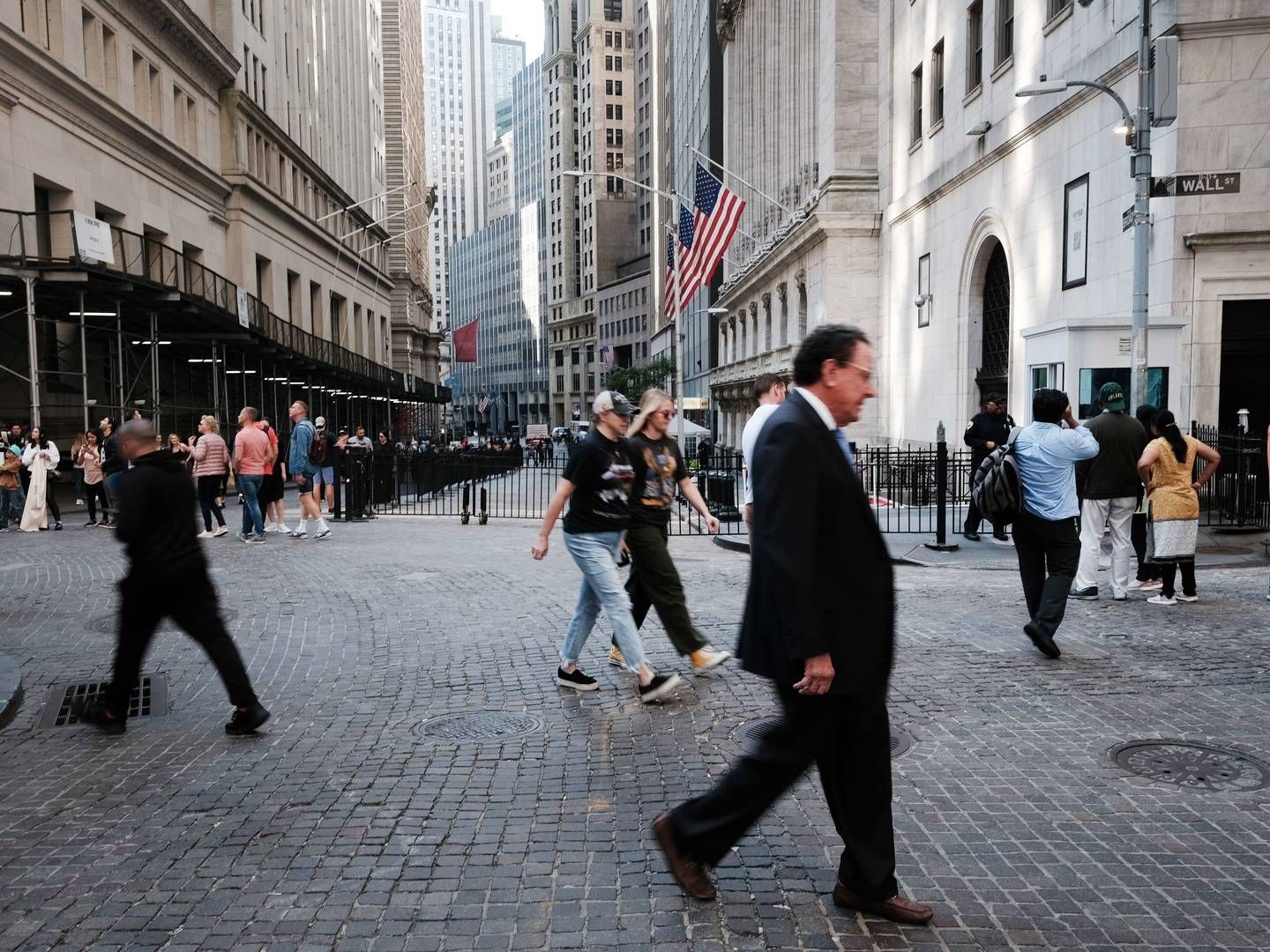 Gående trafik på finansgaden Wall Street i New York, hvor den amerikanske kapitalfond KKR & Co. er børsnoteret. Et nyt samarbejde har åbnet op for, at flere, mindre investorer også kan blive eksponeret mod investeringerne i en af KKR's milliardfonde | Foto: Spencer Platt / AFP / Getty Images / Ritzau Scanpix